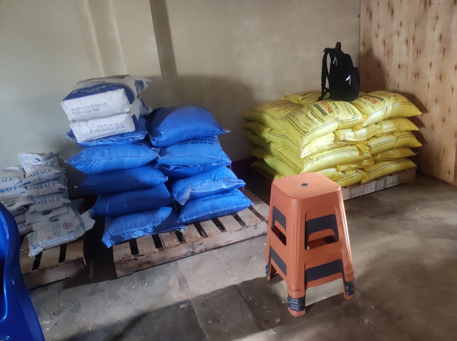 Blue and yellow sacks stacked on wooden pallets