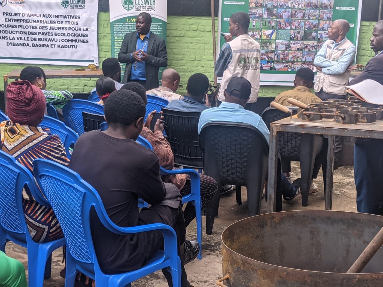 A training session under a banner for ecological pavers in Bukavu